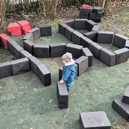 Ein Junge baut aus Bauklötzen die Buchstaben ASB.